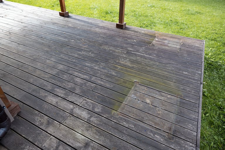 Weathered deck with algae and moss before pressure washing
