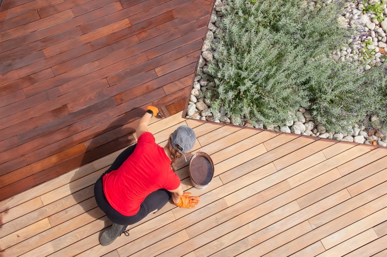 Refreshing of wood deck boards with UV protection pigment oil — staining wooden floor terrace with brush