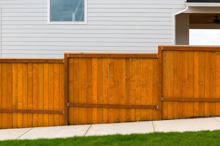 New home backyard red stained cedar wood fence